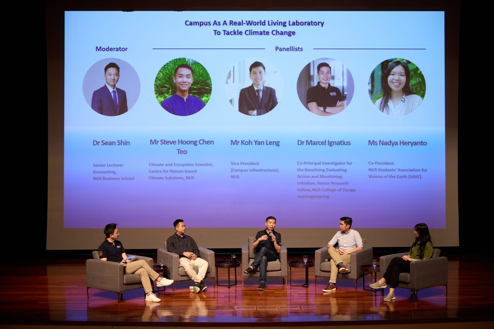On a panel at NUS with the session title on screen behind
